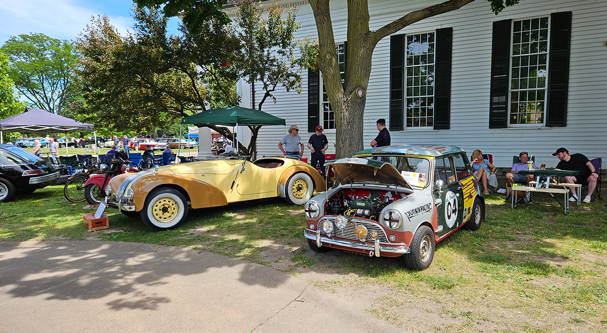 Competition cars like the 1941 Allard K1 at left and the 1962 Austin Mini Cooper at right &mdsah; British vehicles both — sat near Town Hall.