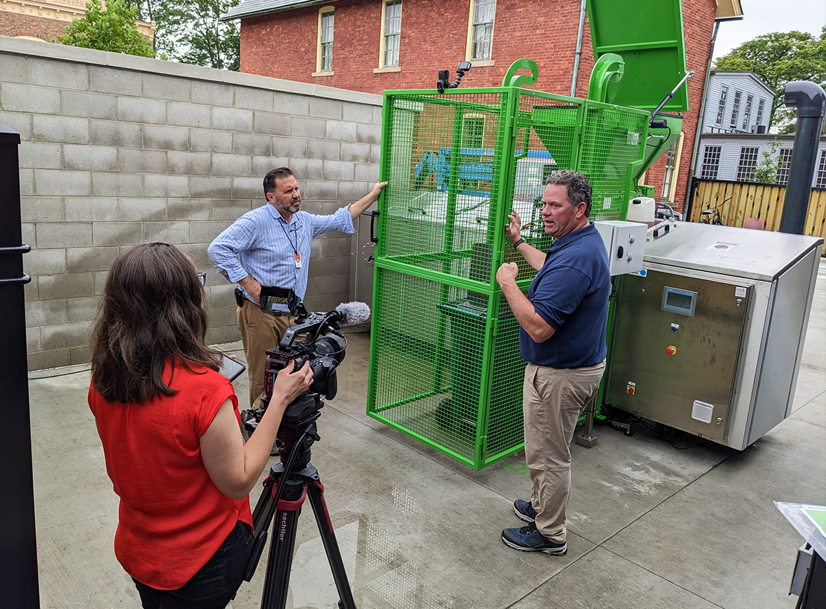 The Henry Ford staff, Amber Stankoff, producer (left) with Brian Egen, executive producer and head of studio productions, filming Alec Jerome, senior director of facilities management and security (right), discussing the biodigester installed at Stand 44, the new restaurant in Greenfield Village, June 26, 2024. Photograph by Debra A. Reid.