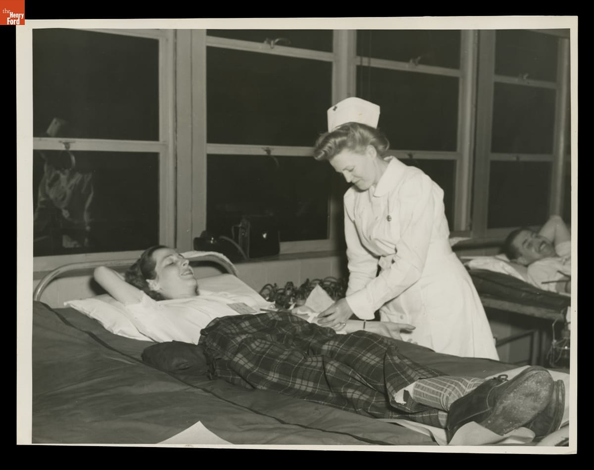 A Red Cross nurse draws blood from a female Ford Motor Company employee at Willow Run Bomber Plant